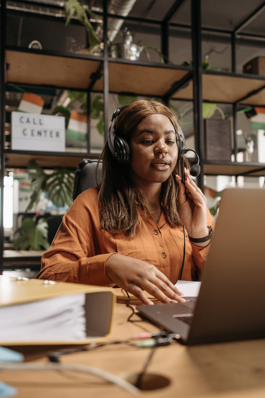 a woman sitting at a desk talking through headphones